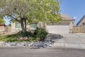 A residential house with a garage, a driveway, and a tree in the front yard. - Mountain-View Patio: 11 Mi to F1 Circuit (North Las Vegas)