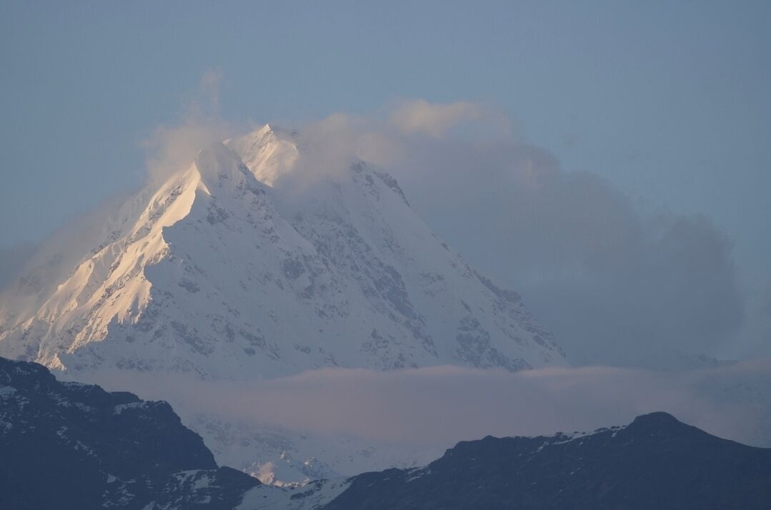 A snow-covered mountain peak with a clear sky.