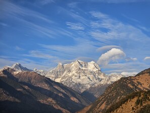 A mountainous landscape with snow-capped peaks and a valley. - Chaukhamba Cradle (Ukhimath)
