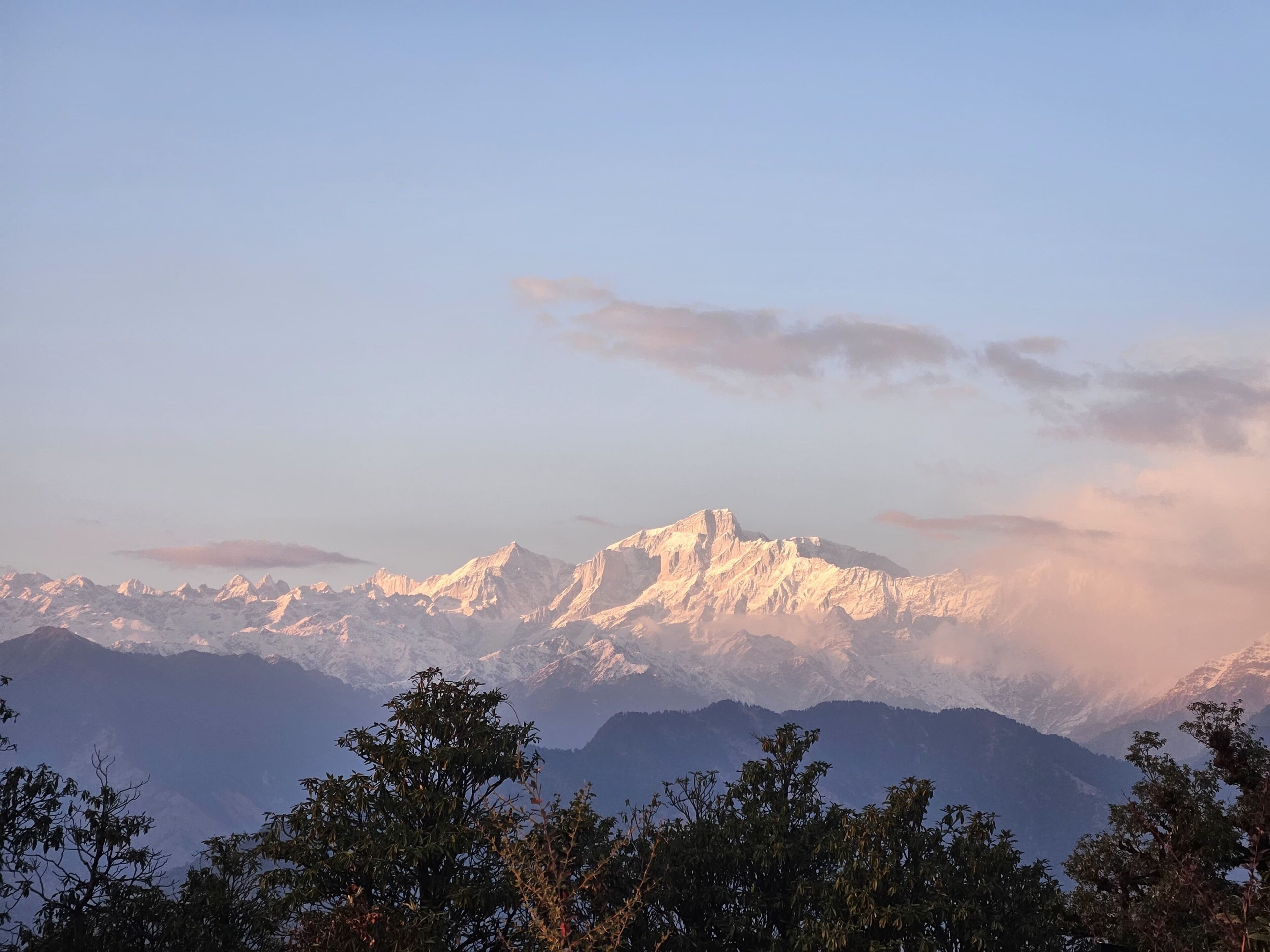 A mountain range with snow-capped peaks and a clear sky.