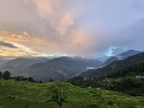 Paisaje montañoso con campos en terrazas y cielo despejado.