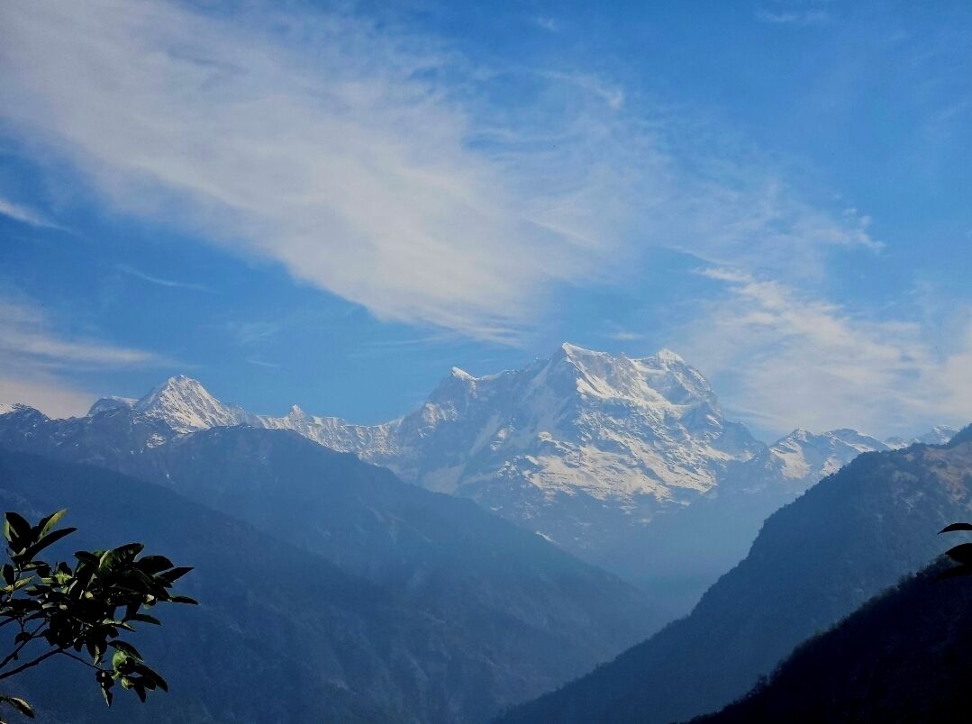 Eine Bergkette mit schneebedeckten Gipfeln unter blauem Himmel.