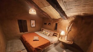 Un dormitorio acogedor con cama, mesita de noche, lámpara y una pequeña alfombra.