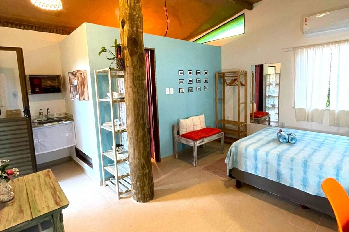 Quarto com cama, cadeira, estante e guarda-roupa.