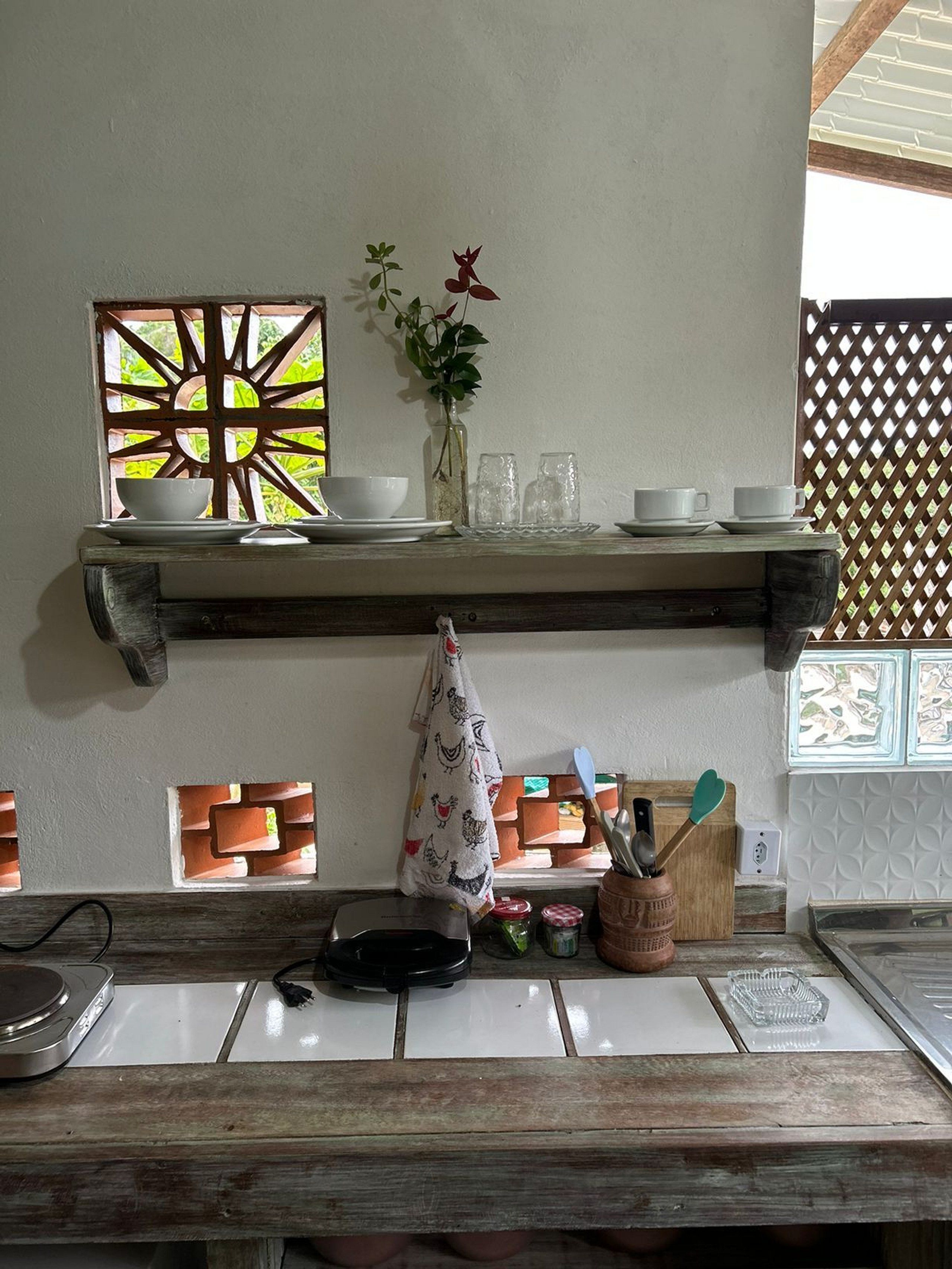 Uma bancada de cozinha com uma torradeira, uma chaleira e uma cafeteira.