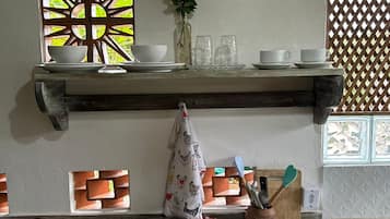 Uma bancada de cozinha com uma torradeira, uma chaleira e uma cafeteira.
