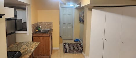 A compact kitchen with wooden cabinets, a built-in microwave, and a small countertop.