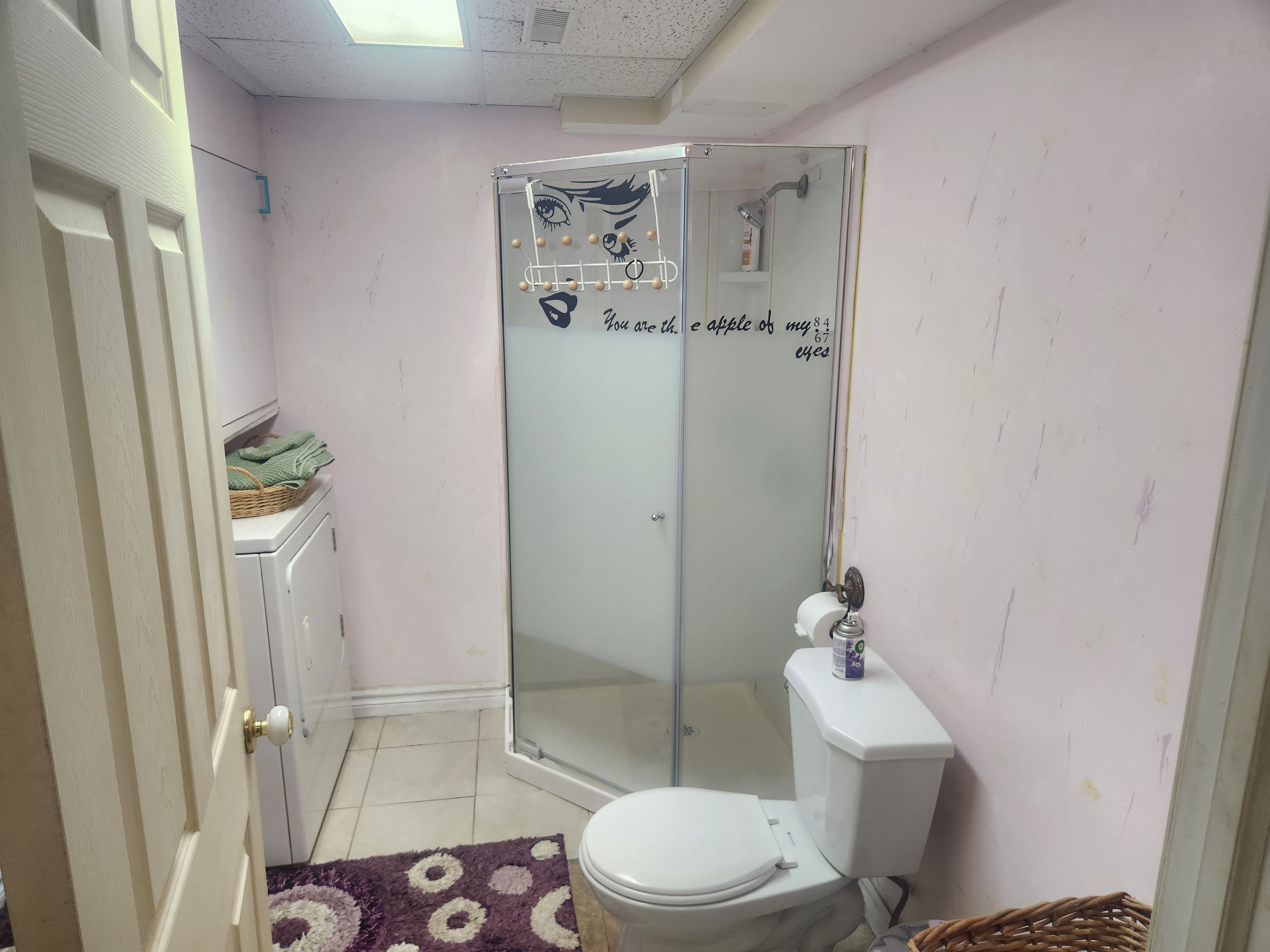Un baño con inodoro, cabina de ducha de vidrio y lavamanos blanco.