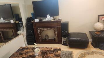 A living room with a television, a fireplace, a coffee table with a vase, and a globe on a side table.