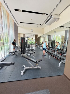 A gym with exercise equipment, mirrors, and a water dispenser. - 10 Mins walk to Walking Street Apartment in Pattaya Jomtien (ตำบล หนองปรือ)