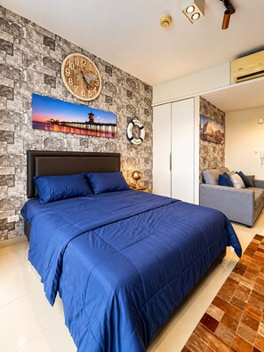 A bedroom with a large bed, a wall clock, a welcome sign, and a view of a sunset. - 10 Mins walk to Walking Street Apartment in Pattaya Jomtien (ตำบล หนองปรือ)