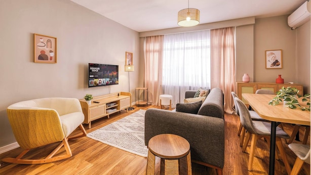 A modern living room with a sofa, armchair, TV, and a dining area with a table and chairs. - Modern, 3BR, Best Location (Kadıköy)