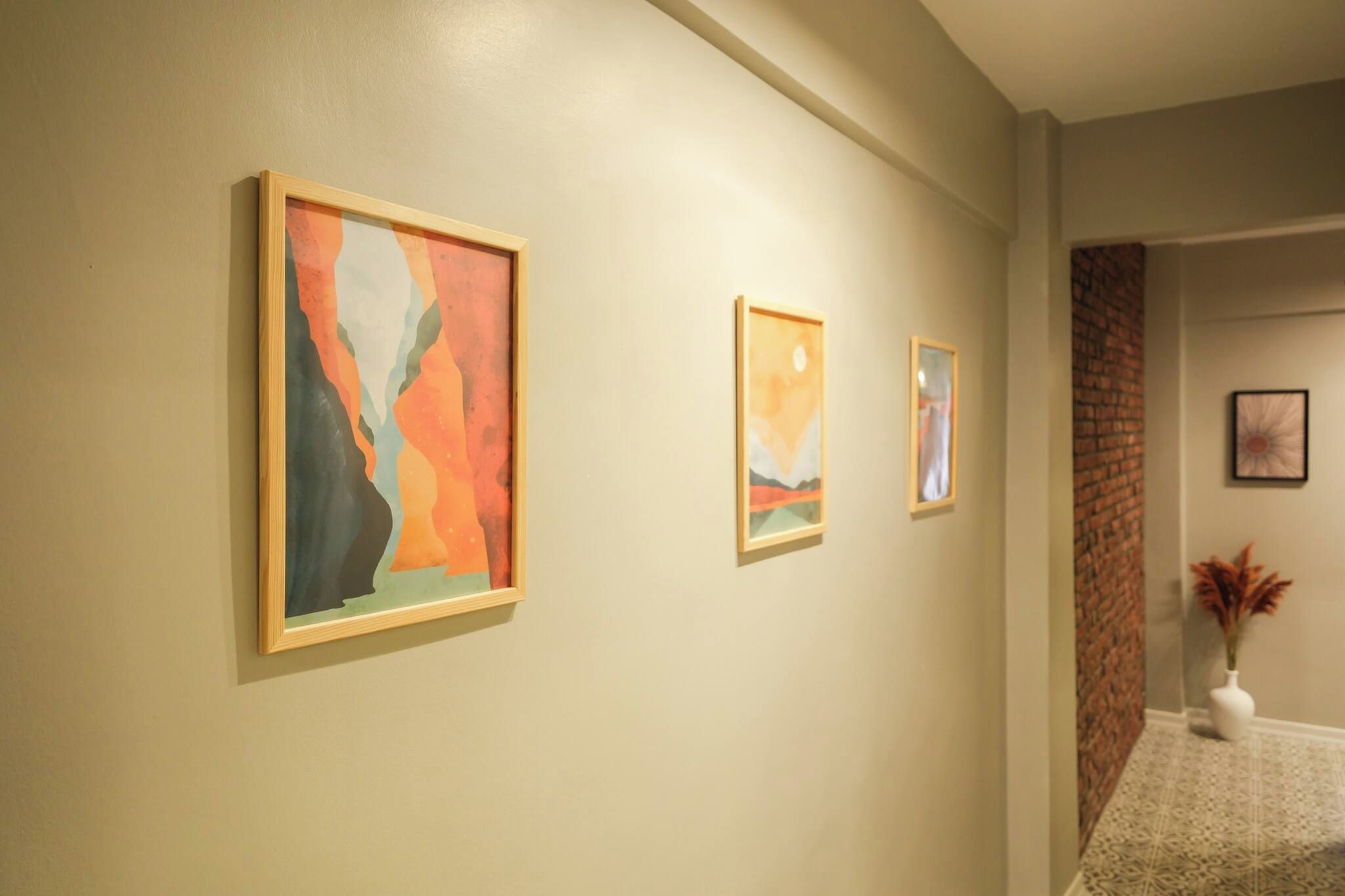 Un couloir orné de trois œuvres d’art encadrées accrochées au mur.