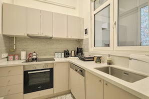 A modern kitchen with a Bosch oven, dishwasher, and a coffee maker. - Historical Building at the Iconic Tram Street, 3BR (Kadıköy)