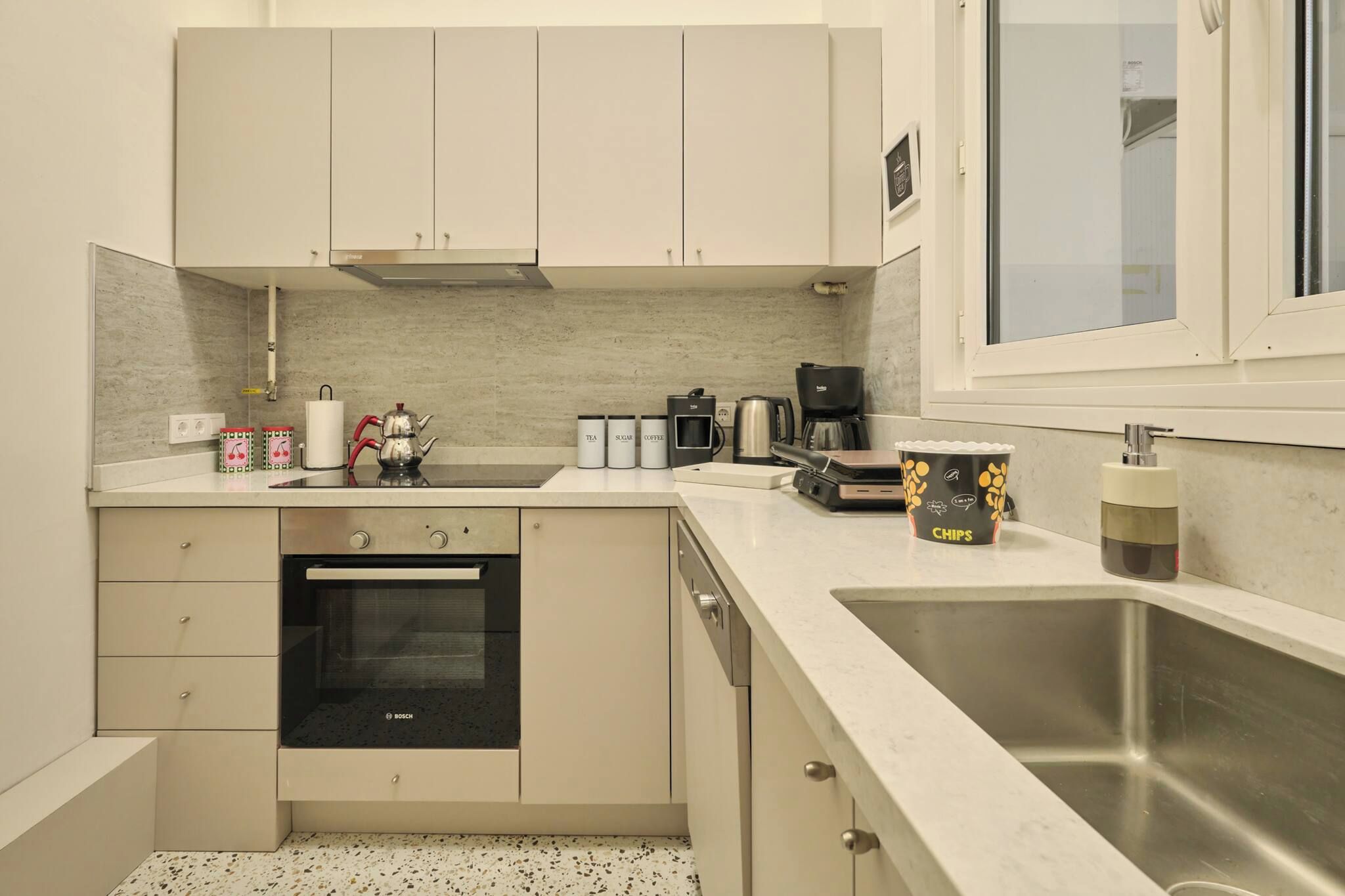 A compact kitchen with a Bosch oven, a coffee maker, and a sink.