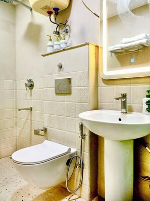 Un baño con inodoro, bidé y lavamanos.
