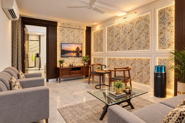 A modern living room with a sofa set, a coffee table, and a television.