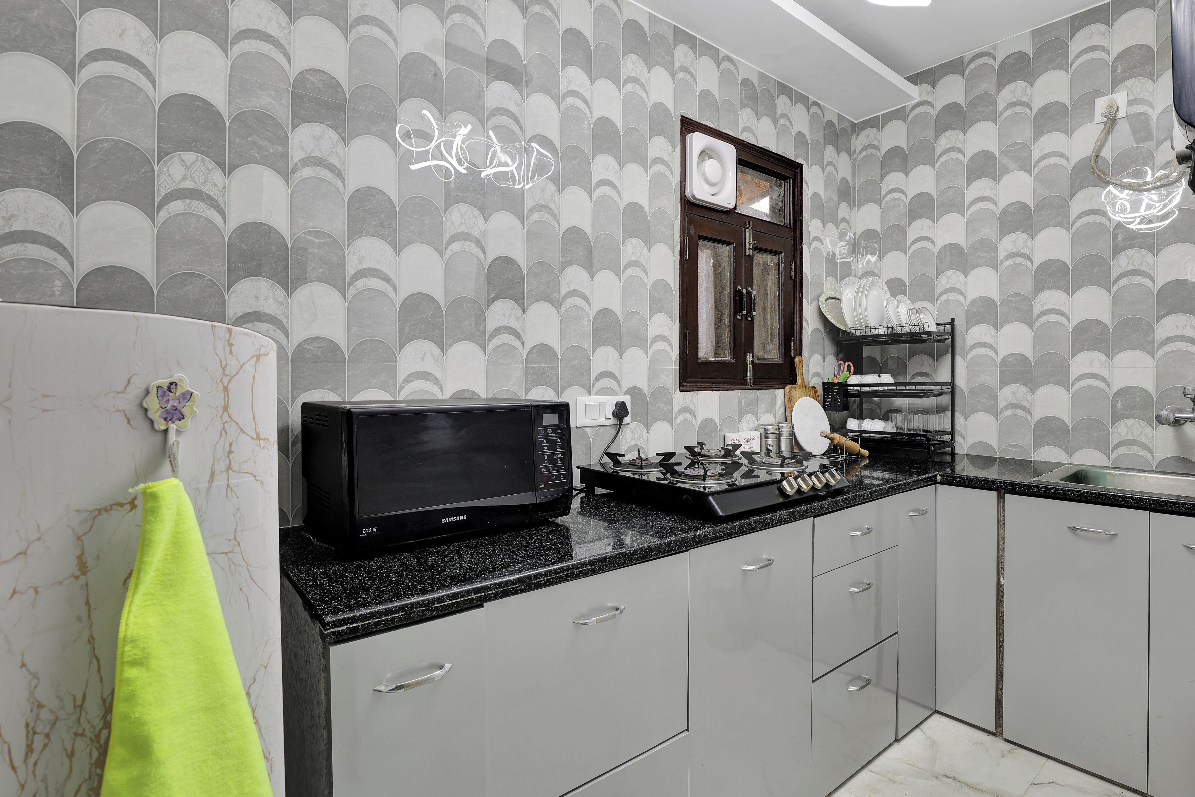 A modern kitchen with a microwave, stove, and dish rack.