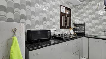 A modern kitchen with a microwave, stove, and dish rack.