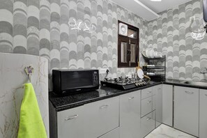 Una cocina moderna con microondas, estufa y escurreplatos.