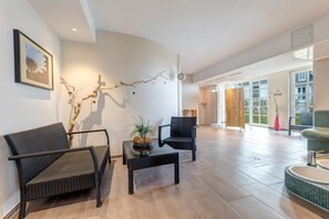 A spacious living area with a modern design, featuring a sofa, armchairs, a coffee table, and a decorative branch on the wall. - Holiday apartment in Benz with swimming pool (Benz)