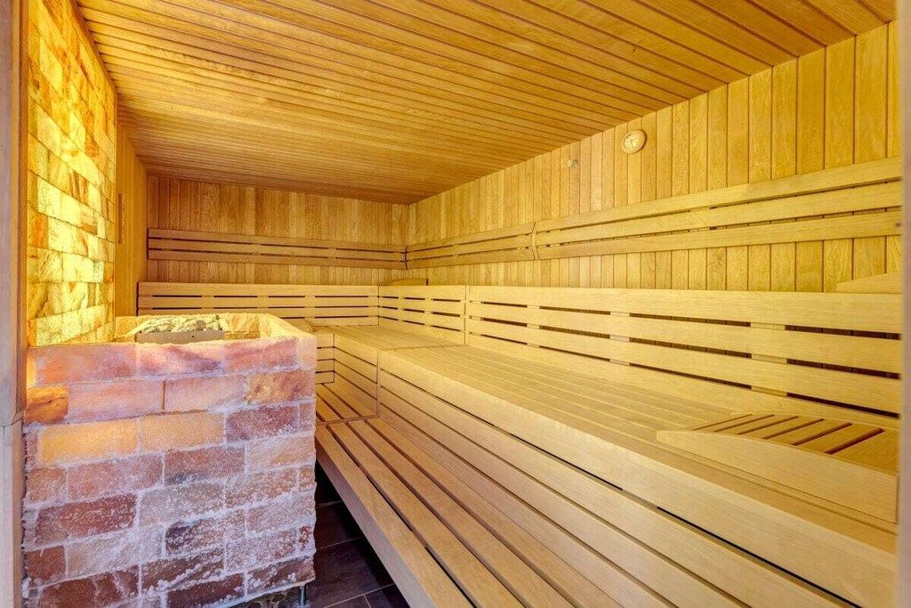 Eine Sauna mit Holzbänken und einer Ziegelwand.