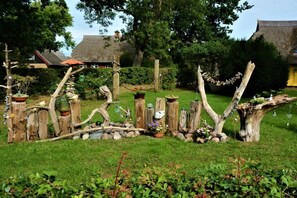 A rustic garden with wooden fences, a stone bridge, and potted plants. - Holiday apartment with 1 bedroom (Ostseeheilbad Zingst)