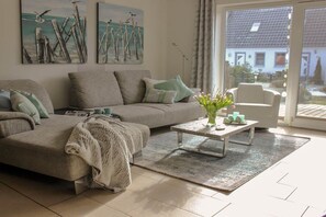 A living room with a sofa, a coffee table, and a chair. There are paintings on the wall and a view through the glass door. - Holiday home in Pruchten with swimming pool (Pruchten)