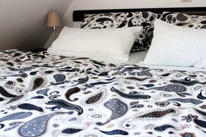 A bed with patterned bedding and a bedside lamp. - Holiday home in Pruchten with swimming pool (Pruchten)