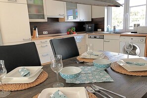 A modern kitchen with a dining area set for a meal. - Holiday home in Pruchten with swimming pool (Pruchten)