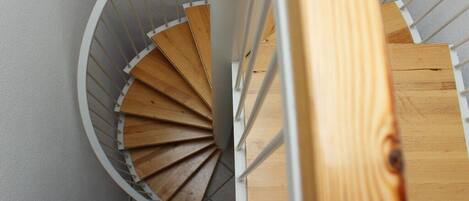 A spiral staircase with wooden steps and white railings.