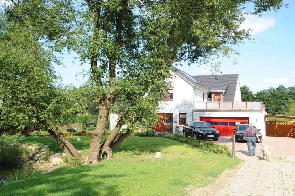 A two-story house with a garage, surrounded by a well-maintained lawn and trees.