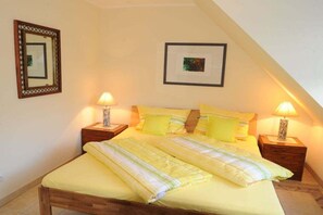 Ein Schlafzimmer mit einem Bett, zwei Nachttischen, einer Ablage und zwei Wandlampen.