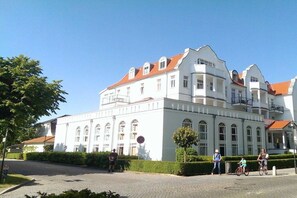 A large white building with arched windows and a red-tiled roof. - Miramare with sun terrace (Kühlungsborn)