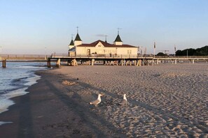A beach with a pier and a building with multiple towers. - Holiday apartment with 1 bedroom (Seebad Ahlbeck)