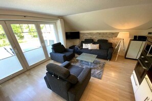 Een moderne woonkamer met een zithoek, een salontafel en een televisie.