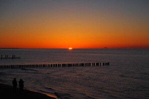 A sunset over a calm sea with a pier extending into the water. - Holiday apartment with 1 bedroom (Zingst)