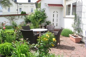 Eine Terrasse mit Korbmöbeln und einer weißen Tür.