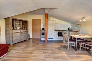 Een ruime keuken met een eethoek, houten kastjes en een visgraatvloer.