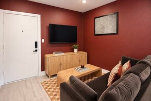 Ein Wohnzimmer mit einer Couch, einem Couchtisch, einem Fernseher und einem Schrank.