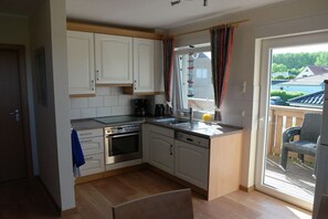 A kitchen with white cabinets, a stove, oven, and dishwasher. - Holiday apartment 2 in the Strandglück house (Glowe)