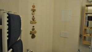 Un baño con toallero, inodoro, lavamanos y espejo.