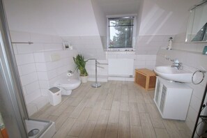 A modern bathroom with a toilet, bidet, sink, and shower. - Holiday apartment with 4 bedrooms (Ostseeheilbad Zingst)