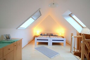 A bedroom with two beds, a wooden wardrobe, a desk, and a skylight. - Holiday apartment with 4 bedrooms (Ostseeheilbad Zingst)
