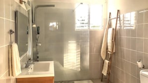 A bathroom with a shower, toilet, and sink. - Vrbo Property (Sainte Anne)