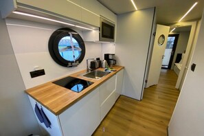 A modern kitchen with a wooden countertop, a built-in stove, a sink, and a window with a view.