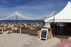 Eine Strandlage mit Liegestühlen und einem Zeltenbereich.