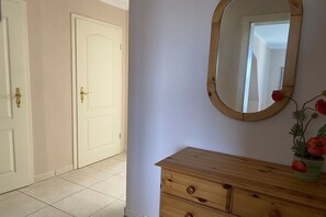 Una habitación con un aparador de madera, un espejo y una puerta.