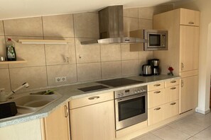 Una cocina moderna con estufa, horno y microondas de acero inoxidable.