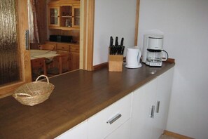 A kitchen with a wooden countertop, a coffee maker, a knife block, and a wicker basket. - Holiday park in Lychen with swimming pool (Lychen)